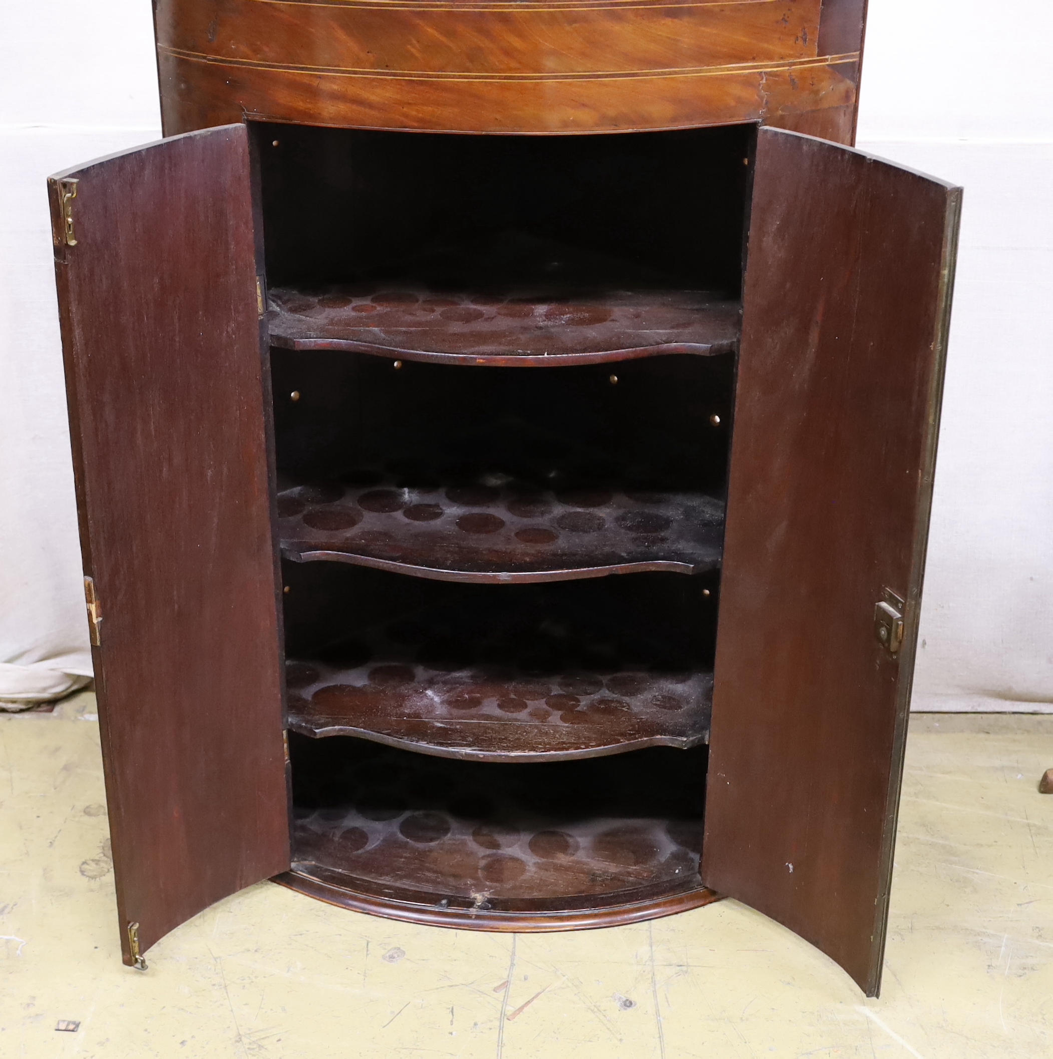 A 19th century George III bow-fronted hanging mahogany corner cupboard, width 84cm, depth 59cm, height 125cm